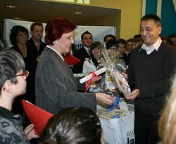 Deniz Dadli übergibt einen Teller an Frau Wieczorek-Zeul
